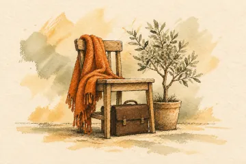 A blanket and sapling beside a chair with a briefcase tucked underneath.